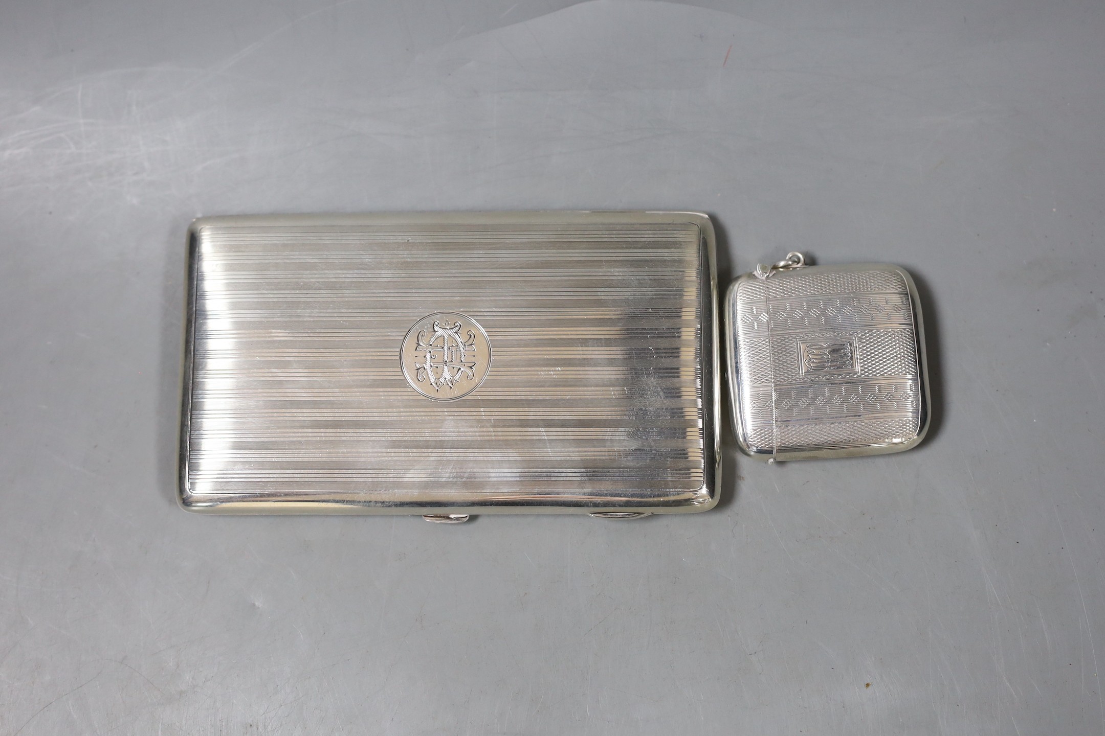 A George V engine turned silver cigarette case, 15cm, and a silver vesta case, gross 8oz.